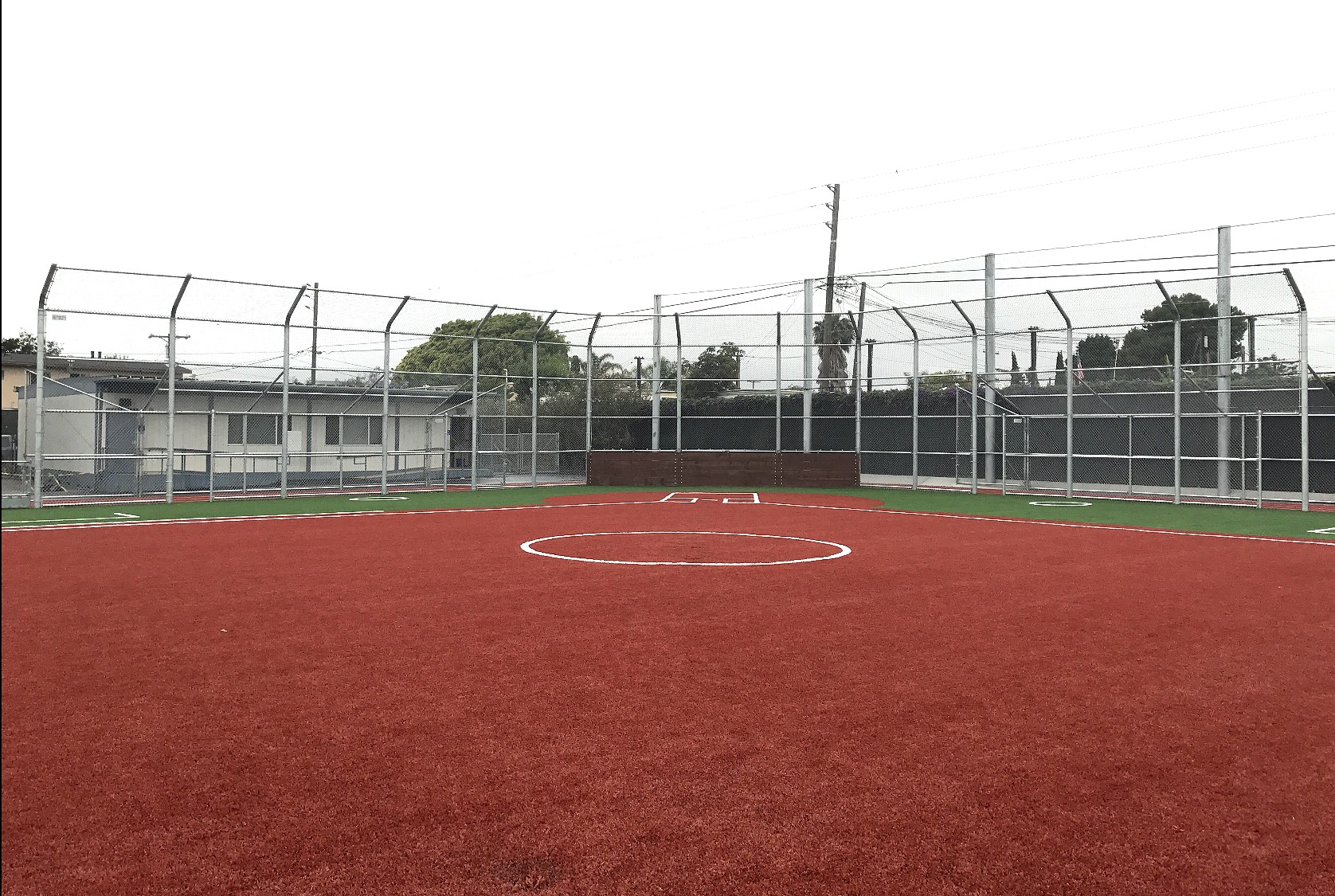 Baseball field backstop with turf
